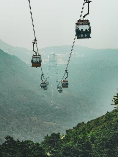 白天青山上空的黑色缆车